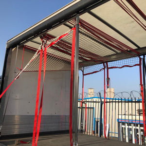 Load control nets with integrated fittings in use as part of a cargo load control system on a curtain side truck.