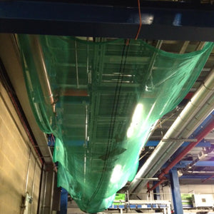 Bespoke debris netting under a conveyor belt in a warehouse (customer photo).