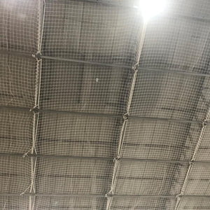 Safety netting under a roof inside a warehouse.