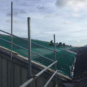 Sacrificial safety netting covering solar panels on a roof.