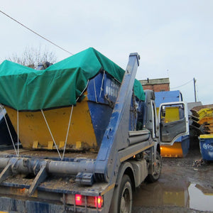 Green debris net covering a skip on a vehicle (customer photo).