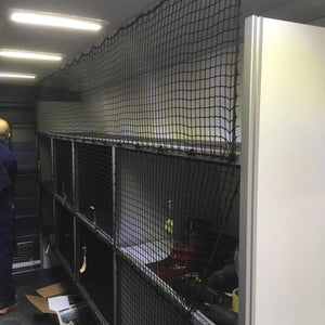 Bespoke non-elastic cargo net with bungee cord and plastic hooks in front of shelving (customer photo).