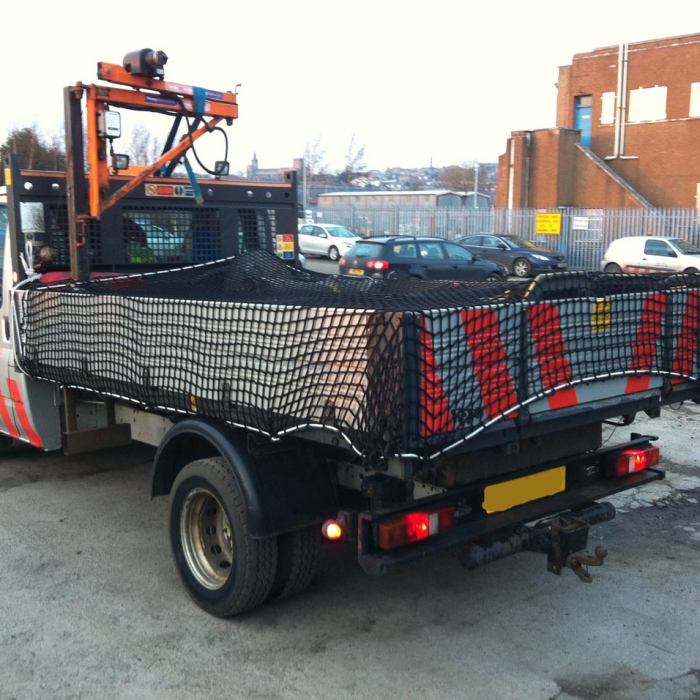 Cargo net covering back of a vehicle trailer.