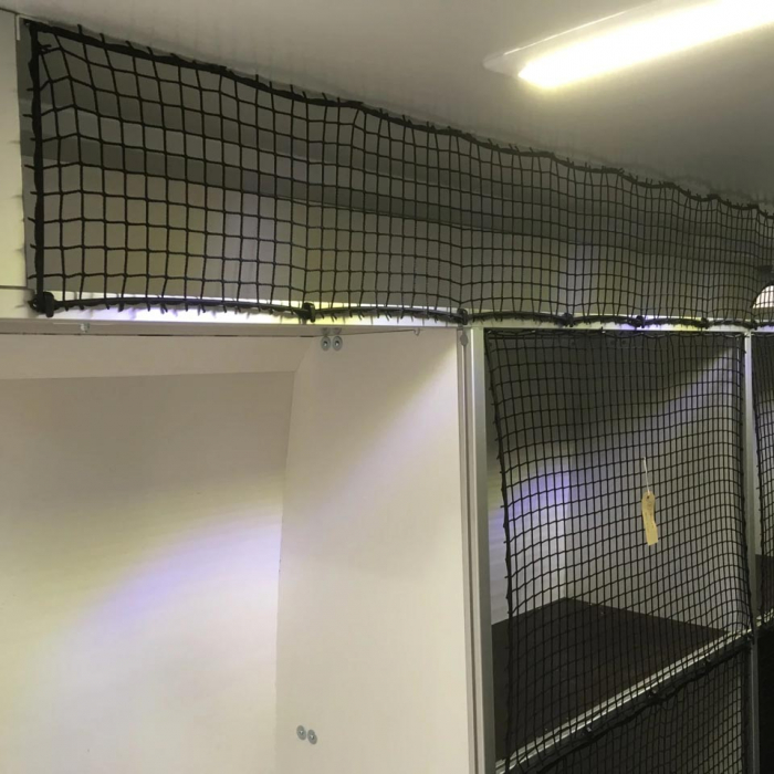 Non-elastic cargo net with bungee cord and plastic hooks in front of shelving.