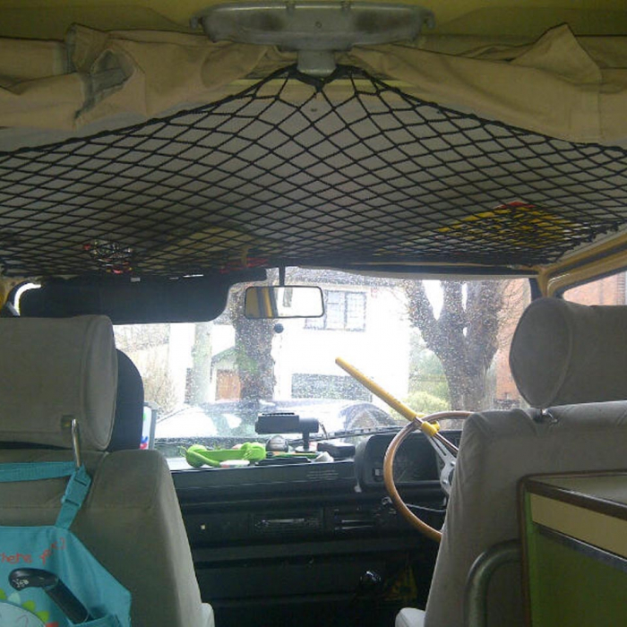 Black elastic net with bungee cord to create storage space on the roof of a camper van.