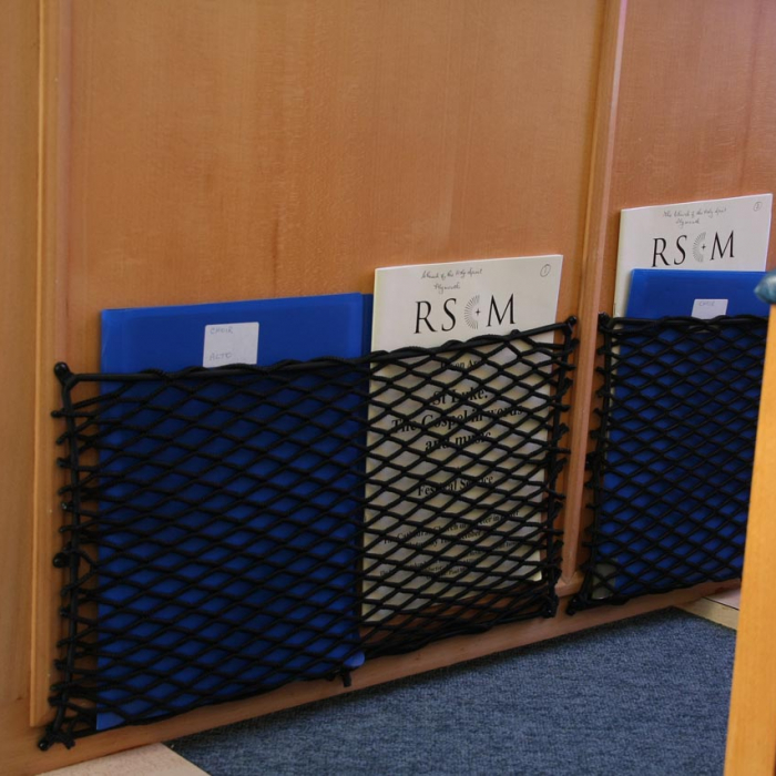 Close-up of bespoke elastic nets for organisation of books and music in a Church