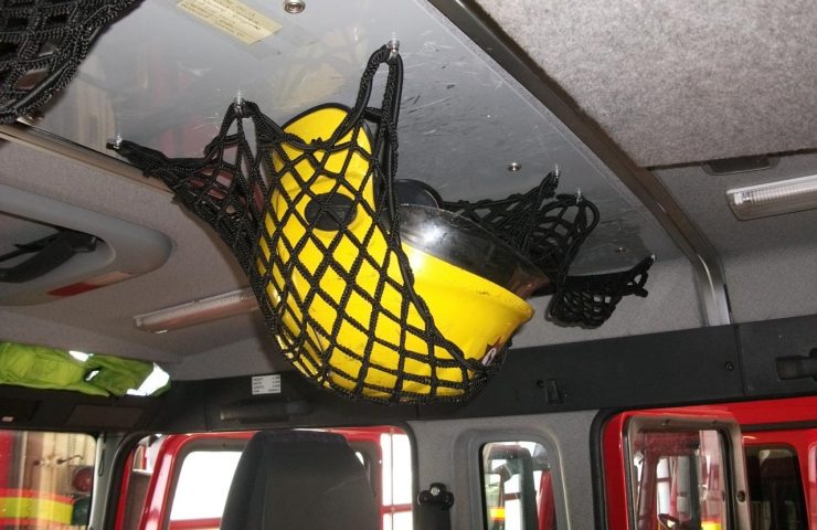 Elasticated nets in use on roof of fire truck for helmet stowage