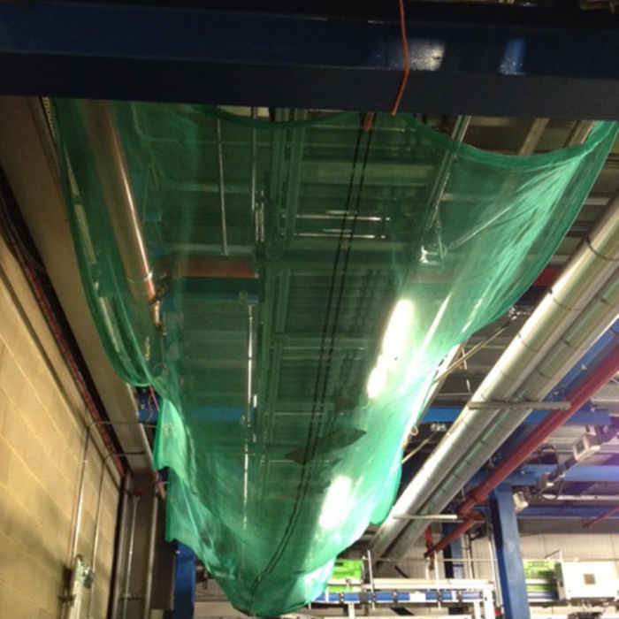 Green Mesh net under Conveyor Belt in warehouse.