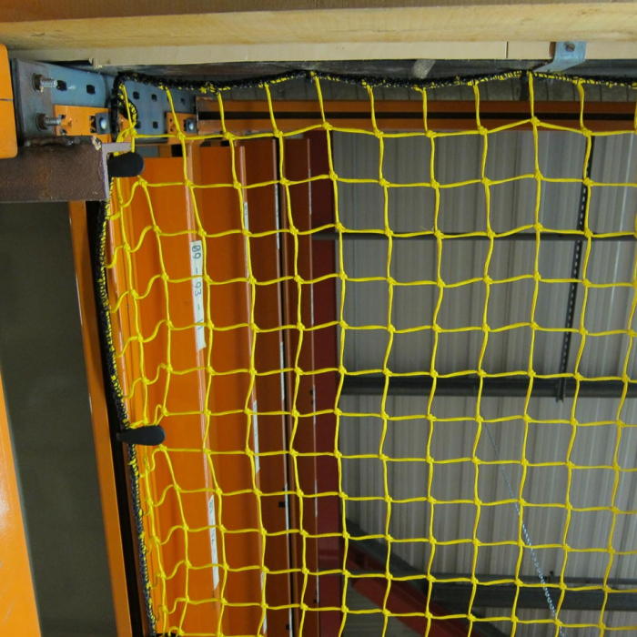 Close-up of yellow knotted netting in a warehouse.